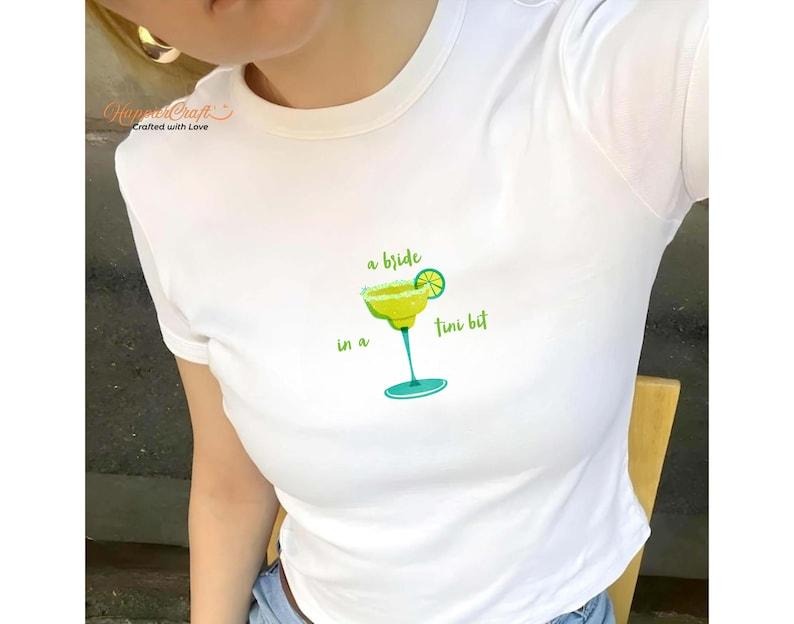 [Sale Up To 20%] A Bride In A Tini Bit Bachelorette Y2K Baby Tee, Cocktail Bachelorette Party Trendy Baby Tee, Bride To...